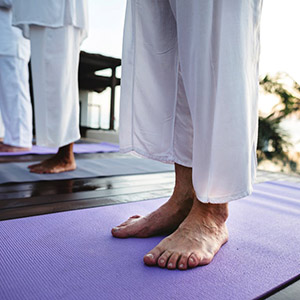 feet standing on yoga mat - thumbnail